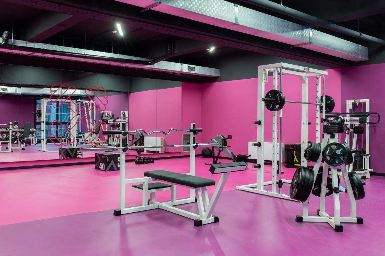 een sportschool met roze muren en loopbanden bij CX Turin Marconi in Turijn