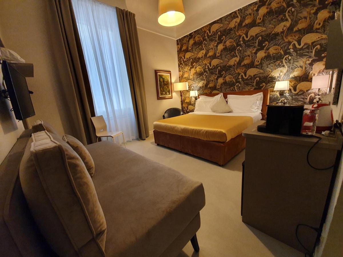 een hotelkamer met twee bedden en een bank bij Hotel Maxim Axial in Florence