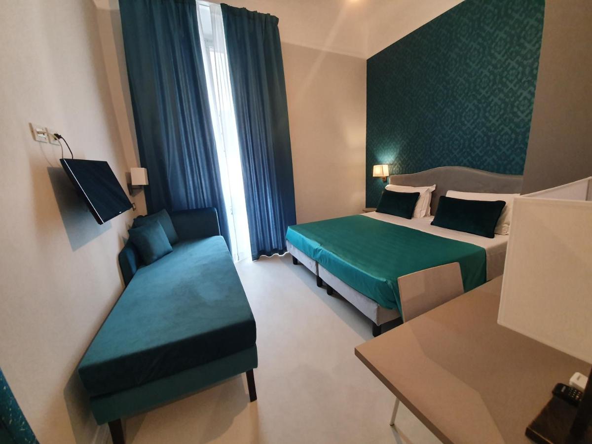een hotelkamer met twee bedden en een stoel bij Hotel Maxim Axial in Florence