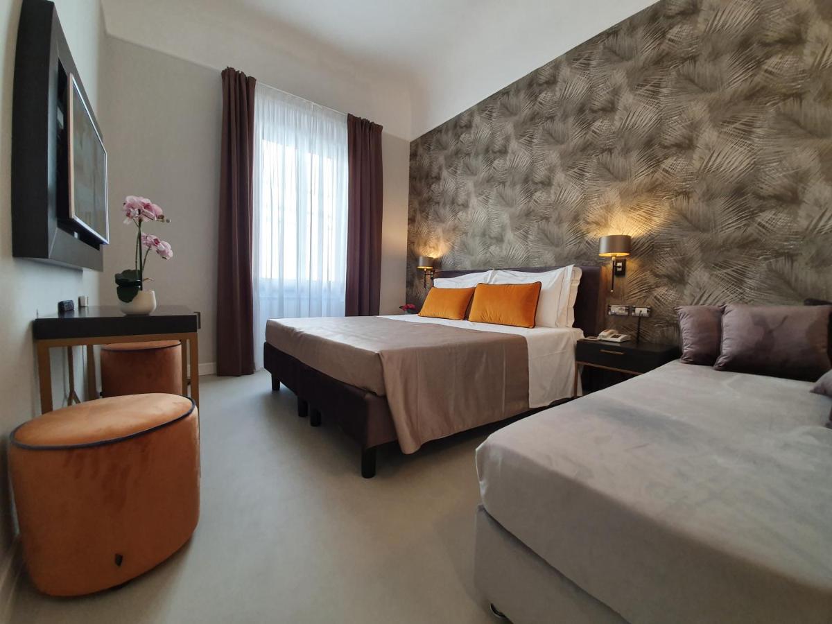een hotelkamer met twee bedden en een bank bij Hotel Maxim Axial in Florence
