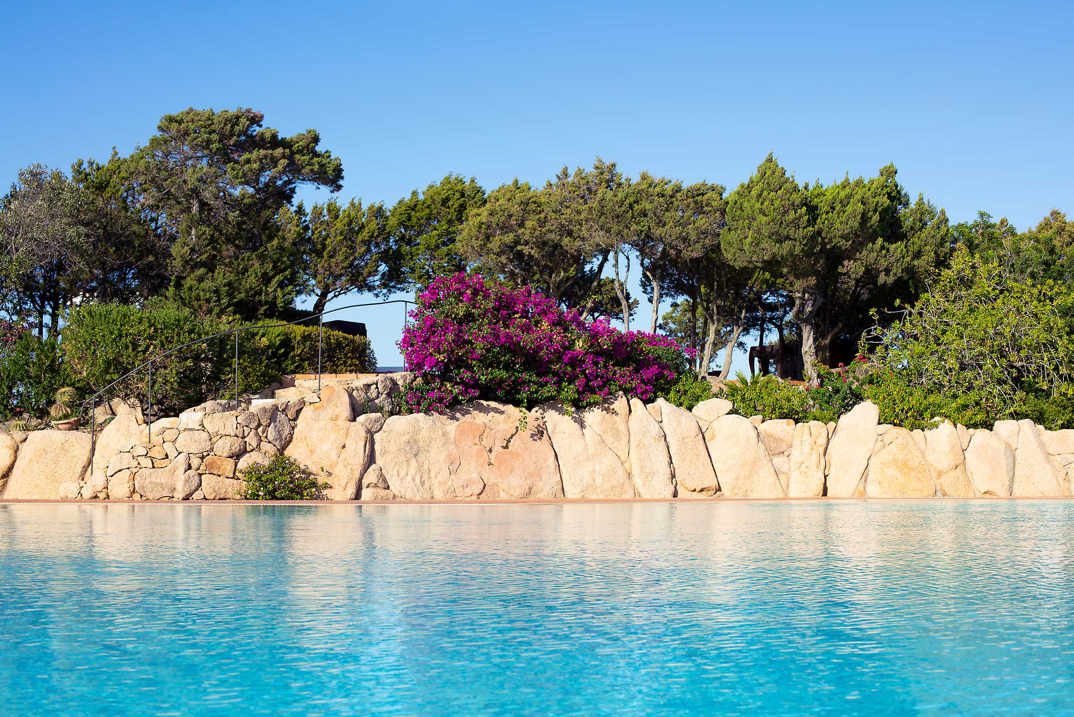 Zwembad omringd door palmbomen — Grand Hotel in Porto Cervo