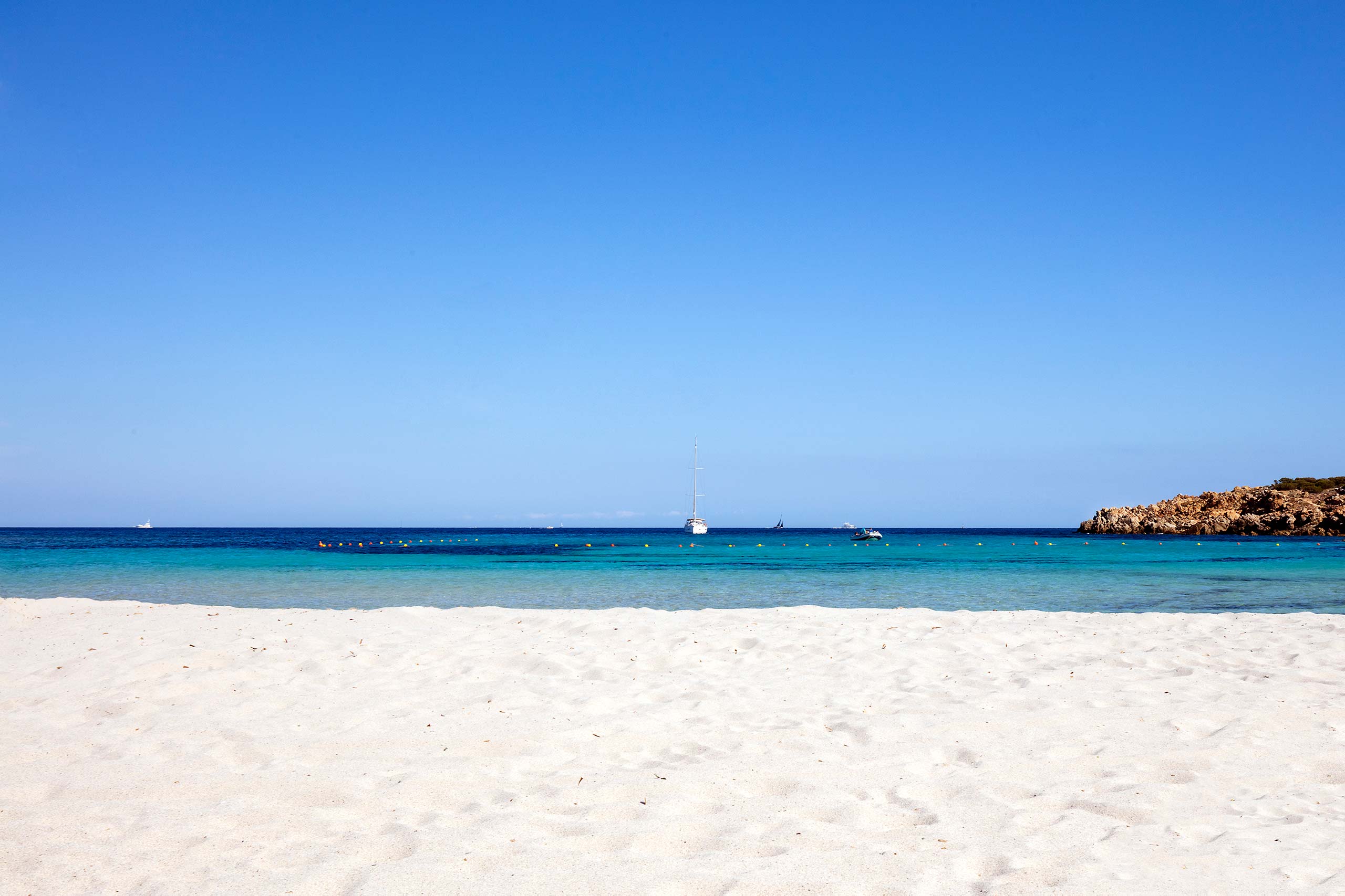 Wit zandstrand met turquoise water — Grand Hotel in Porto Cervo
