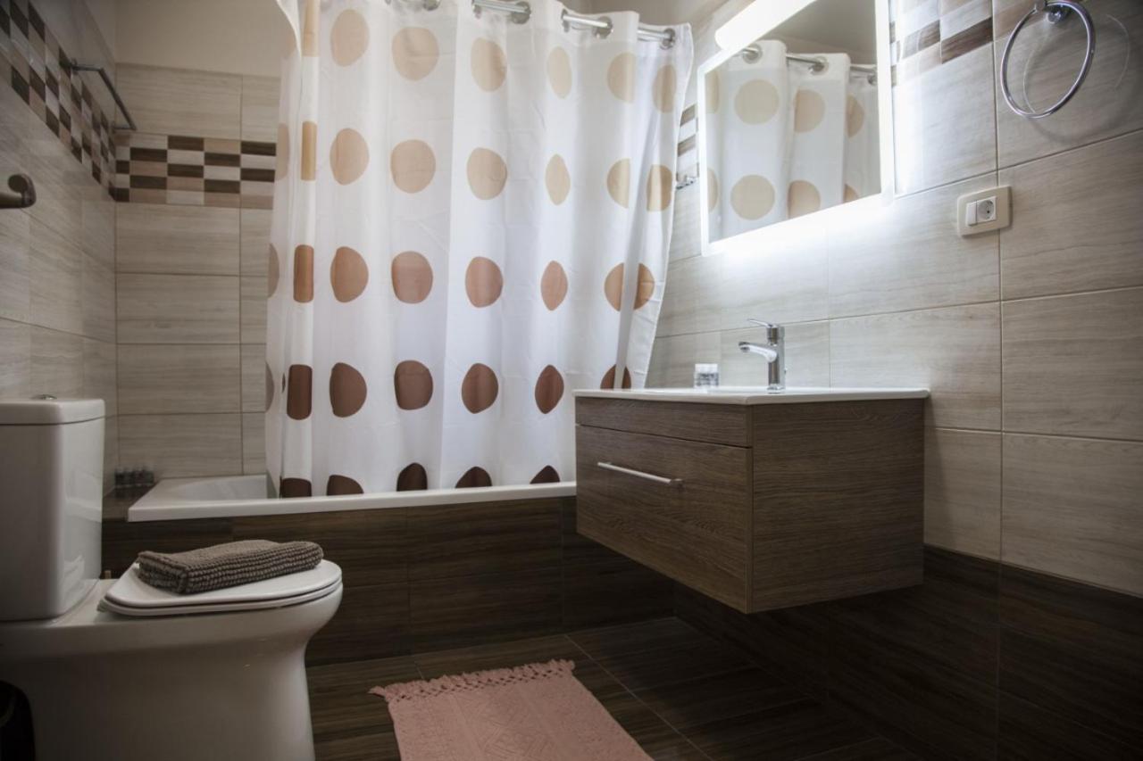 een badkamer met een toilet en een douchegordijn bij Paporas Apartments in Svoronata