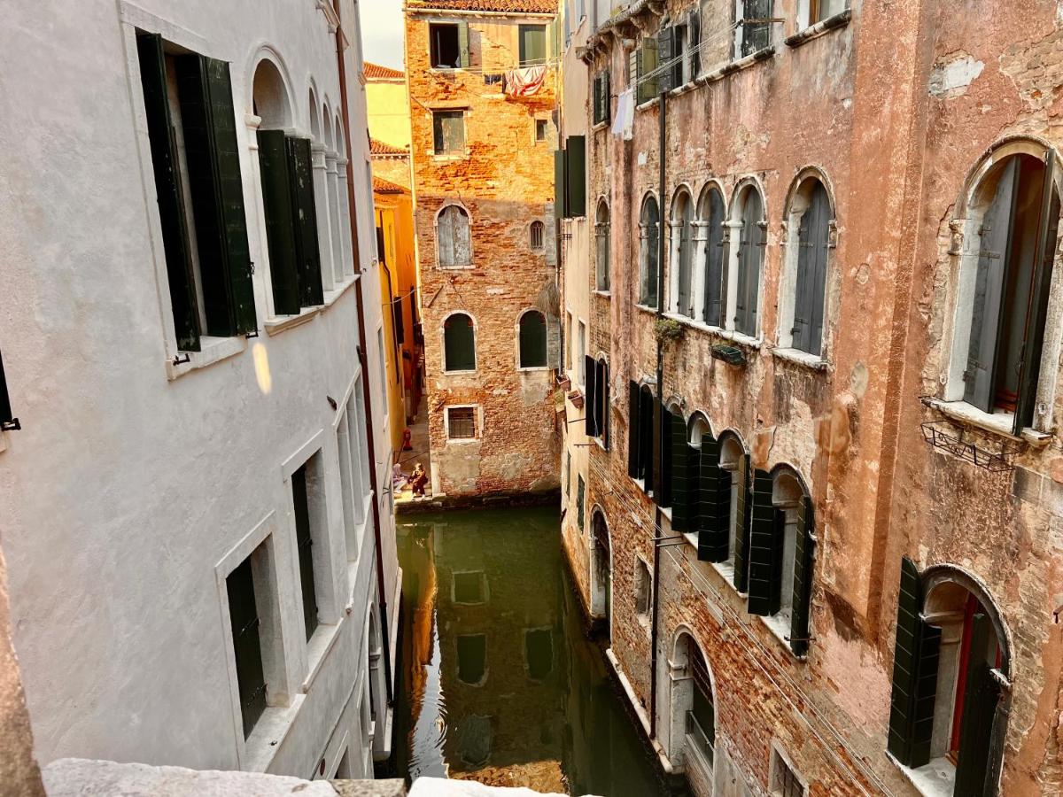 een uitzicht op een kanaal tussen twee gebouwen bij Hotel Canada in Venetië