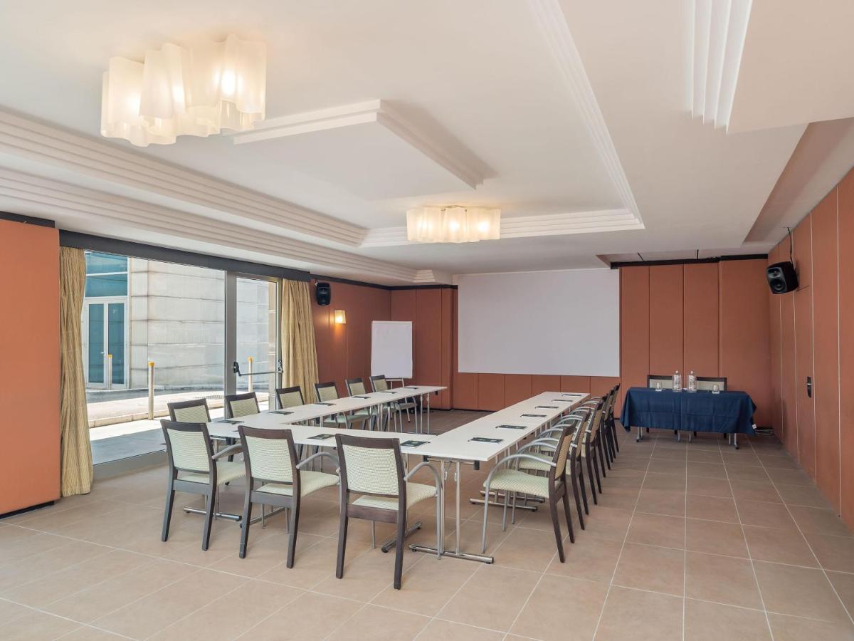 een vergaderruimte met tafels en stoelen en een scherm bij B&B HOTEL Napoli San Mauro in Casalnuovo di Napoli