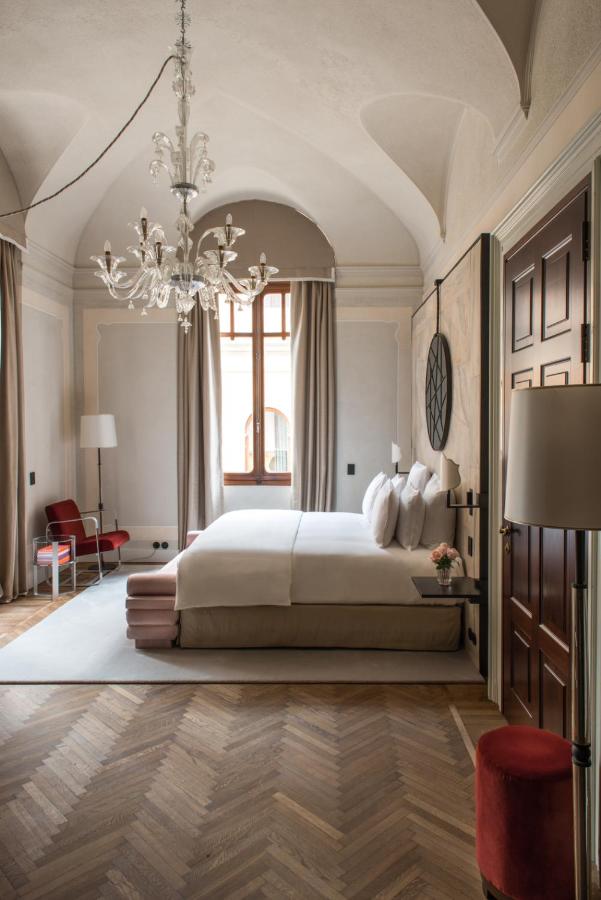 een slaapkamer met een groot bed en een kroonluchter bij Nolinski Venezia - Evok Collection in Venetië