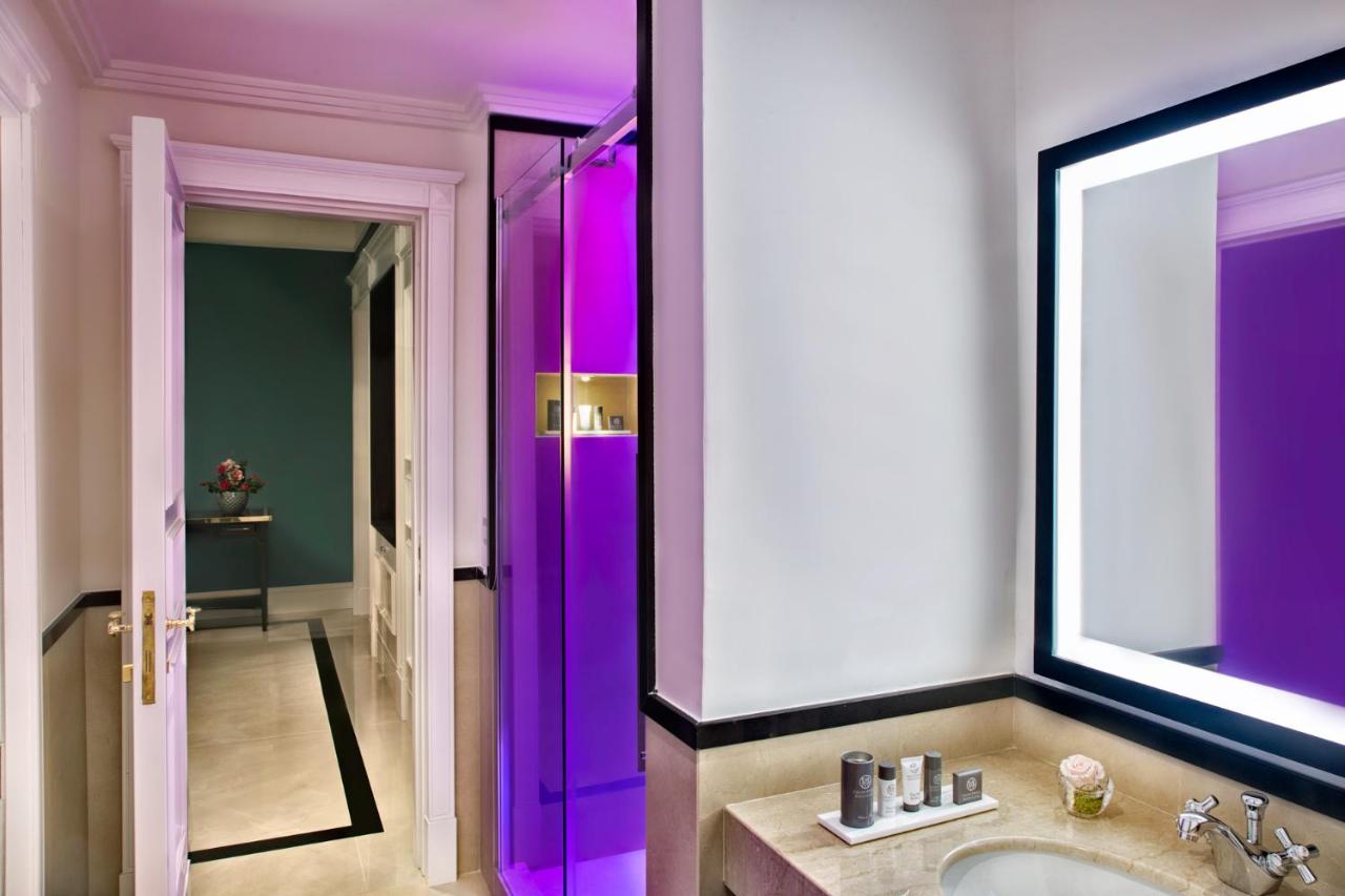 een badkamer met een wastafel en paarse verlichting bij Grand Hotel Santa Lucia in Napels