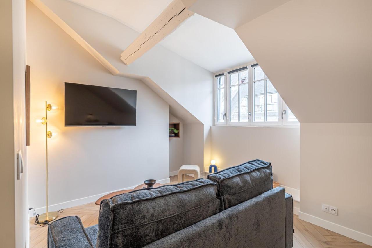 een woonkamer met een bank en een tv bij Gaïa Palace Hôtel N6 in Tours