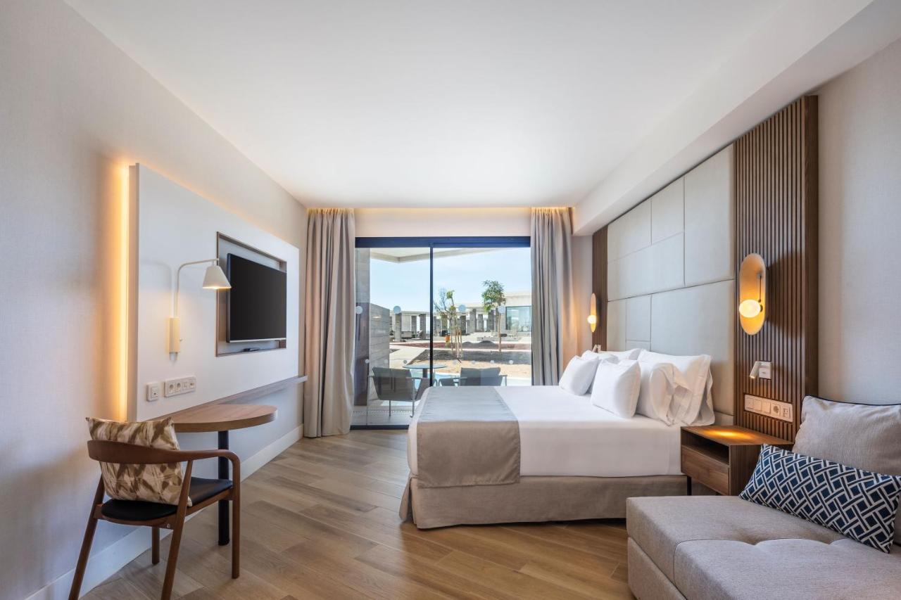 een hotelkamer met een bed en een bank bij Barceló Playa Blanca Royal Level - Adults Only in Playa Blanca