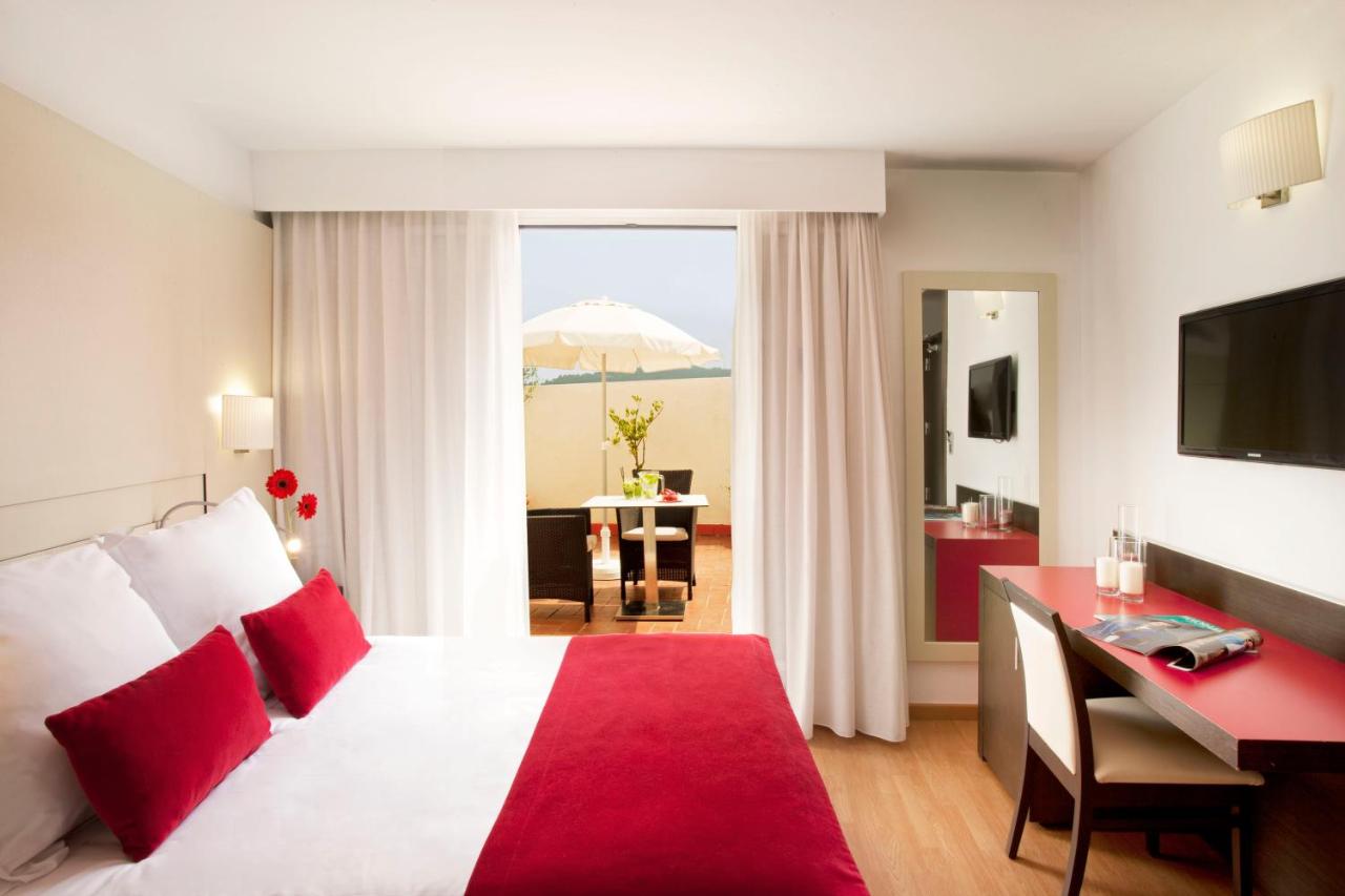 een hotelkamer met een bed, een bureau en een paraplu bij Grupotel Gravina in Barcelona +62 foto's