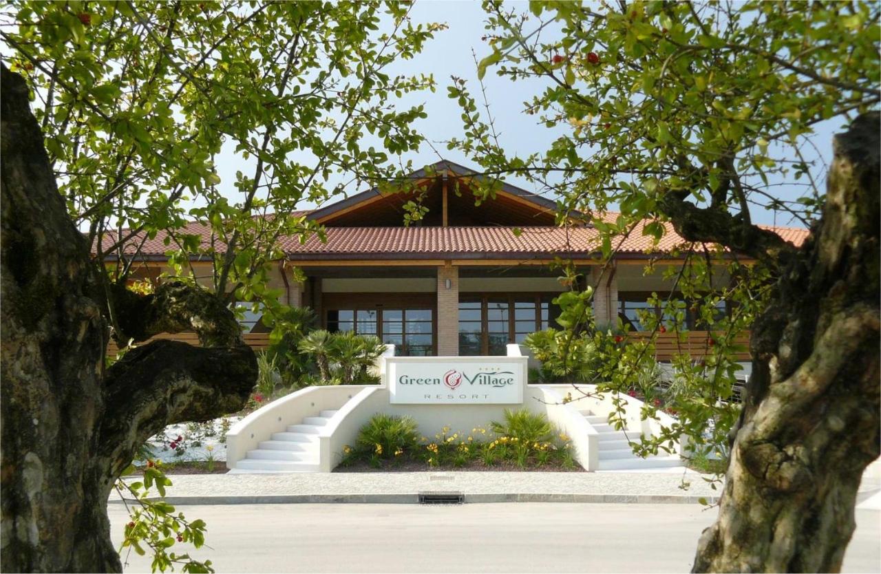 een gebouw met een uithangbord ervoor bij Green Village Eco Resort in Lignano Sabbiadoro