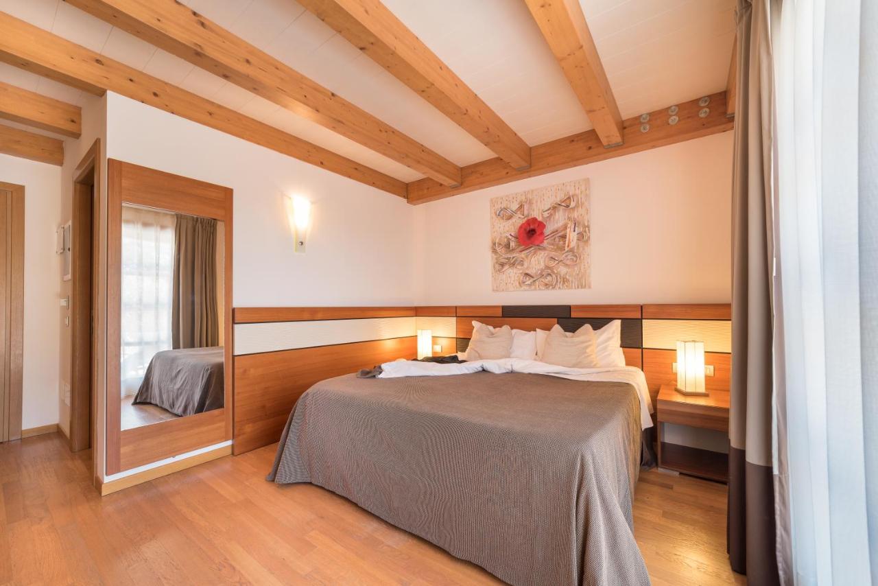 een slaapkamer met een bed en een spiegel bij Green Village Eco Resort in Lignano Sabbiadoro