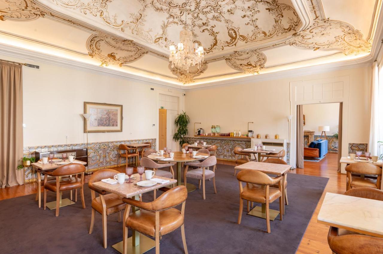 een restaurant met tafels en stoelen en een plafond bij Memoria Lisboa FLH Hotels in Lissabon