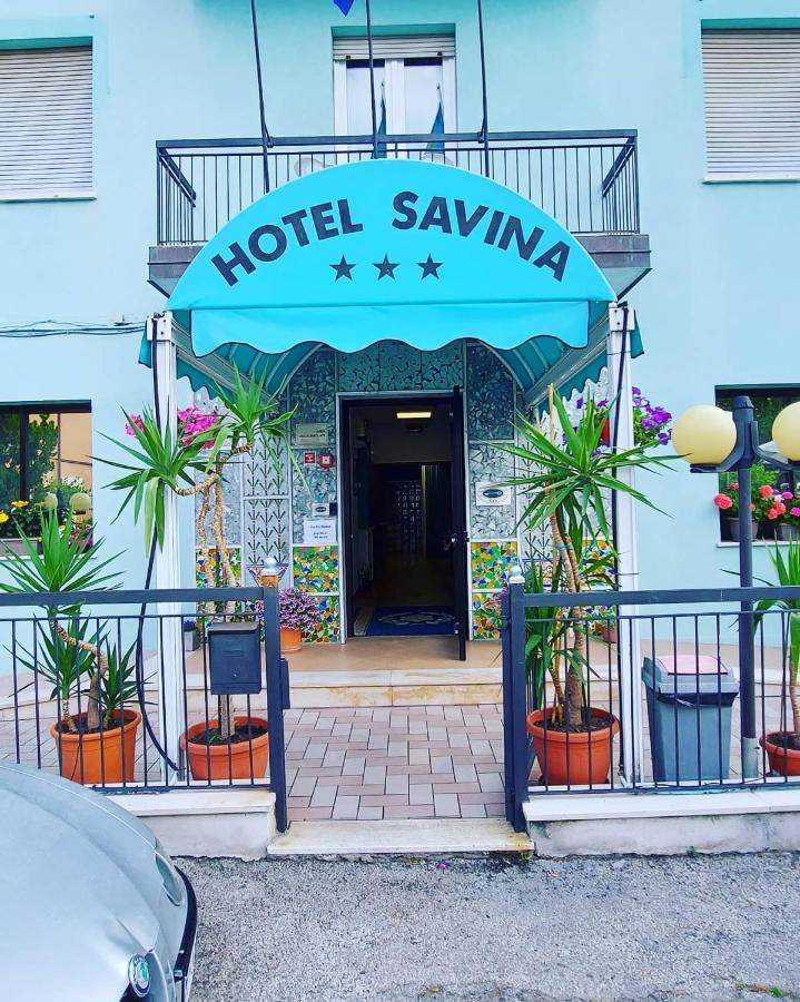een hotelagentschapsbord aan de voorkant van een gebouw bij Hotel Savina in Rimini