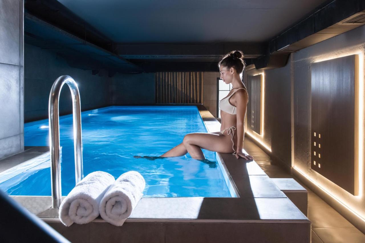 Een vrouw zit in een zwembad. bij San Antonio Boutique Hotel & Spa - Adults Only in Chersonissos