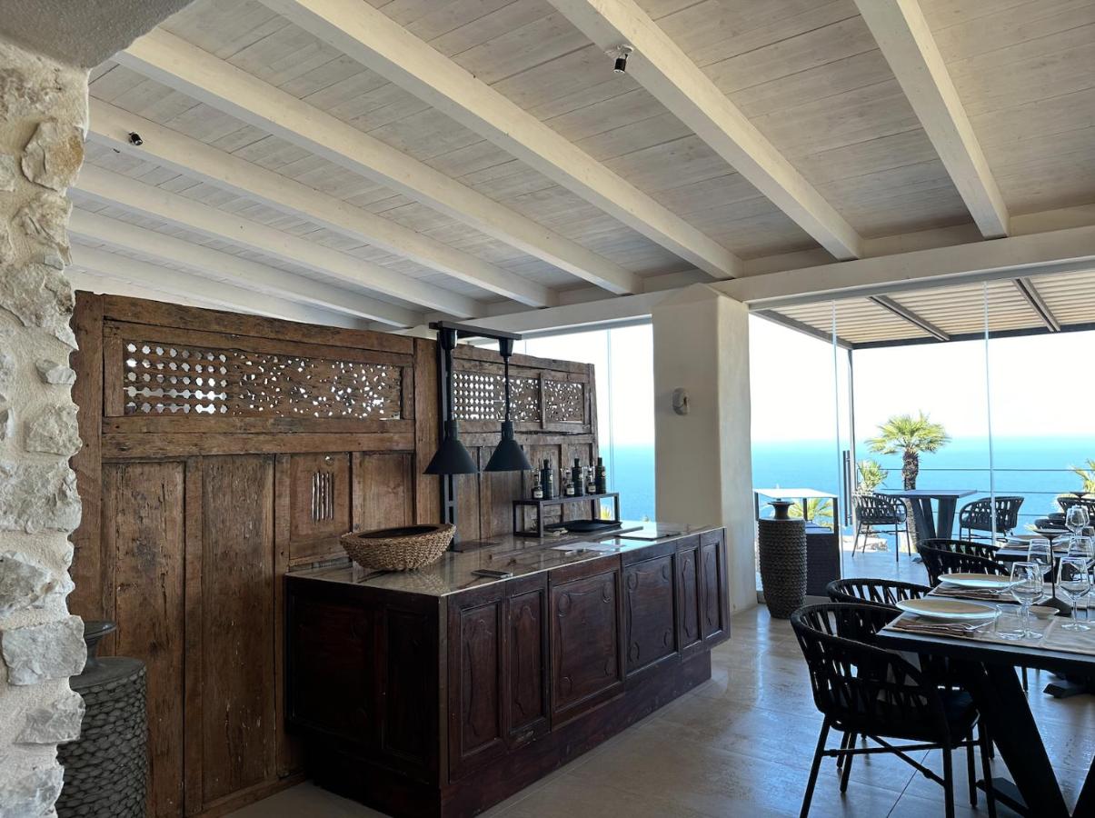 een eetkamer met een bar en een tafel met stoelen bij Baglio La Porta by Geocharme in San Vito lo Capo
