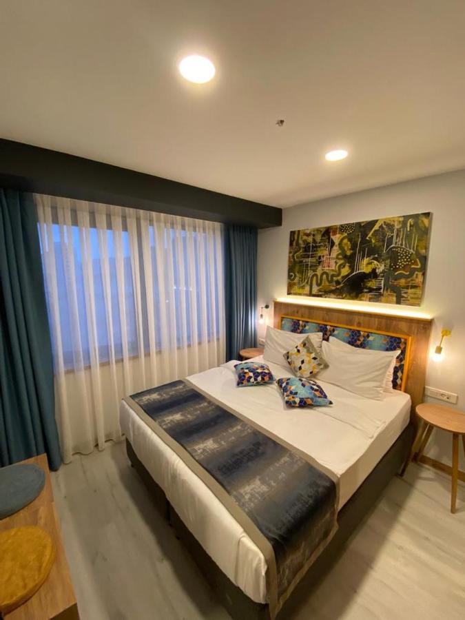 een slaapkamer met een groot bed en een groot raam bij The Gate Kadıköy Downtown in Istanbul