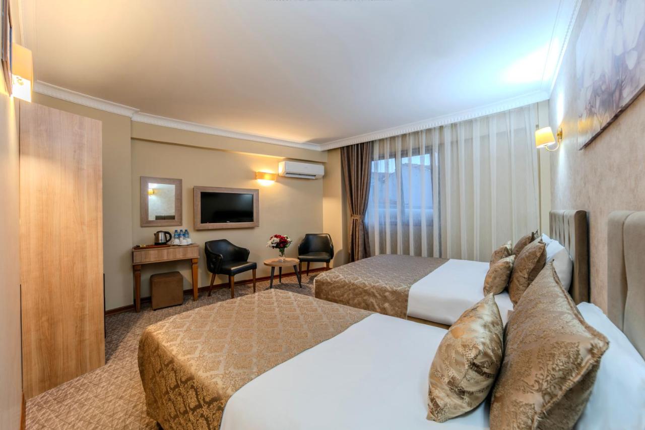 een hotelkamer met twee bedden en een bureau bij Sultan Hamit Hotel in Istanbul