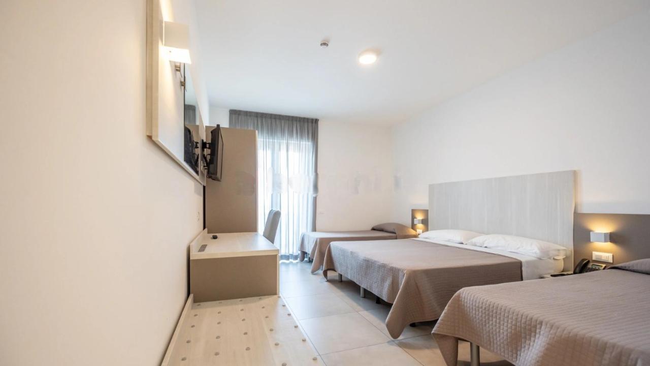 een hotelkamer met twee bedden en een raam bij Nuovo Hotel SettiBi in Giulianova