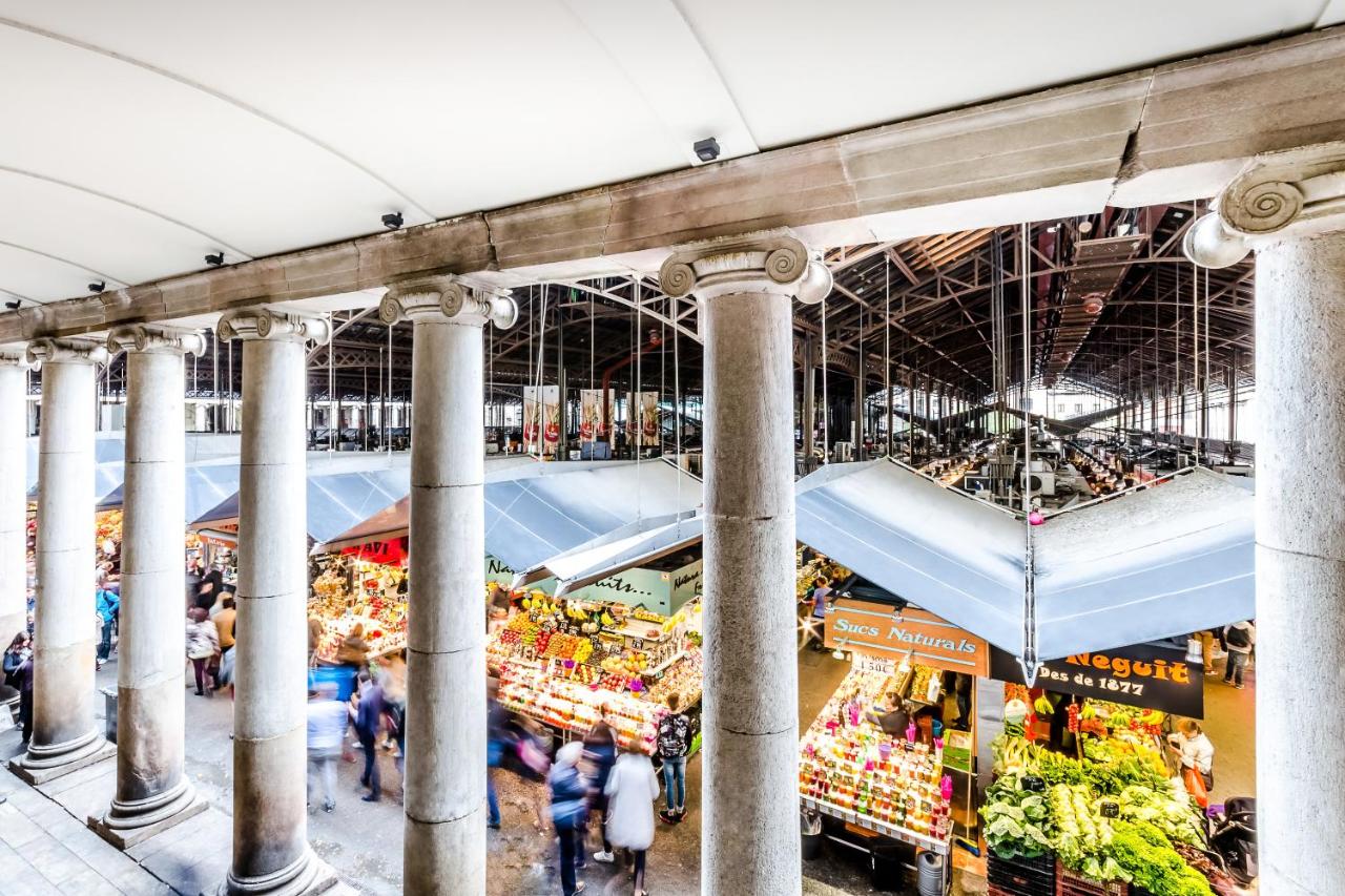 een beeld van een markt met mensen die erdoorheen lopen. bij Dorma Ramblas Boquería in Barcelona