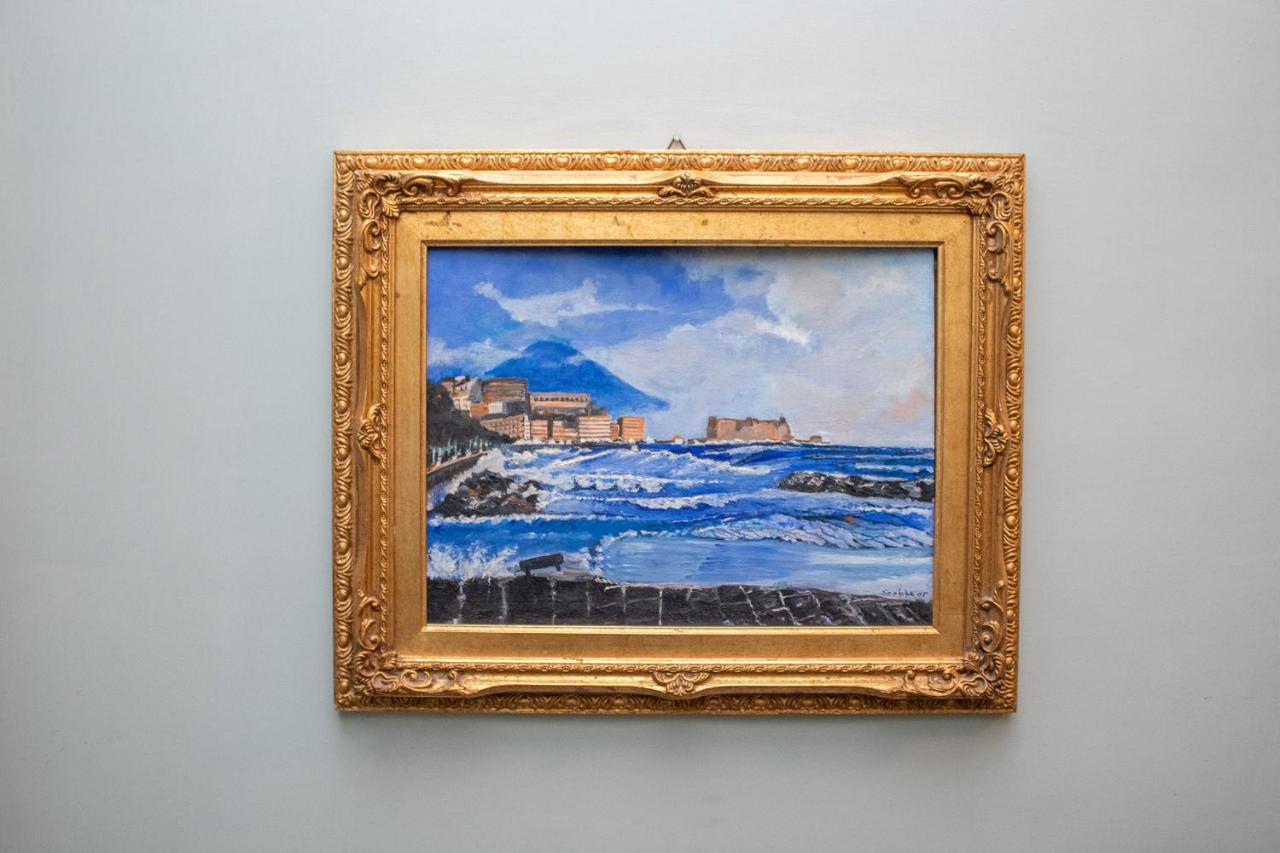 een schilderij van de oceaan in een gouden lijst aan de muur bij Le Stanze Del Vicerè Boutique Hotel in Napels +50 foto'