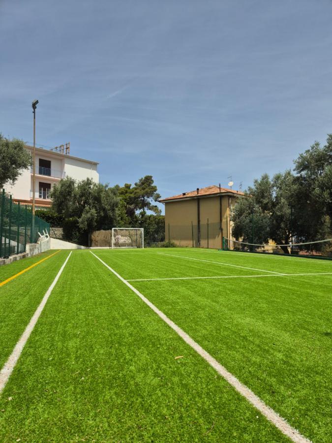 een groen voetbalveld met een gebouw op de achtergrond bij Hotel Guardacosta in Diamante