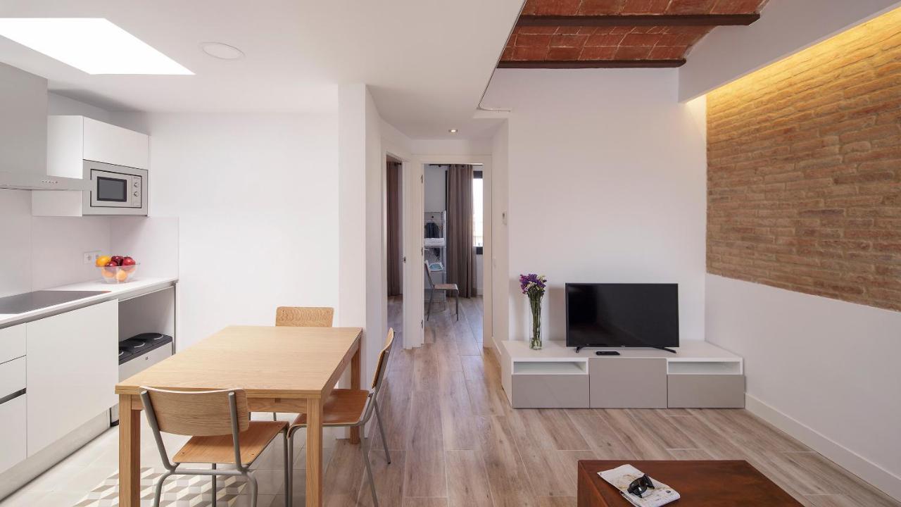 een keuken en eetkamer met een tafel en een televisie bij Hotel Sagrada Familia Apartments in Barcelona