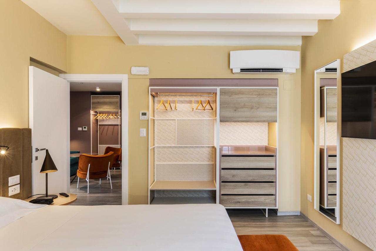een slaapkamer met een wit bed en een bureau bij Adesso Hotel in Rome