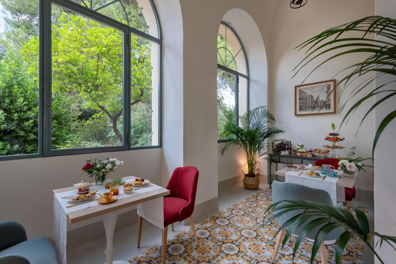 een eetkamer met twee tafels en twee ramen bij Palazzo Donna Elisabetta in Manduria