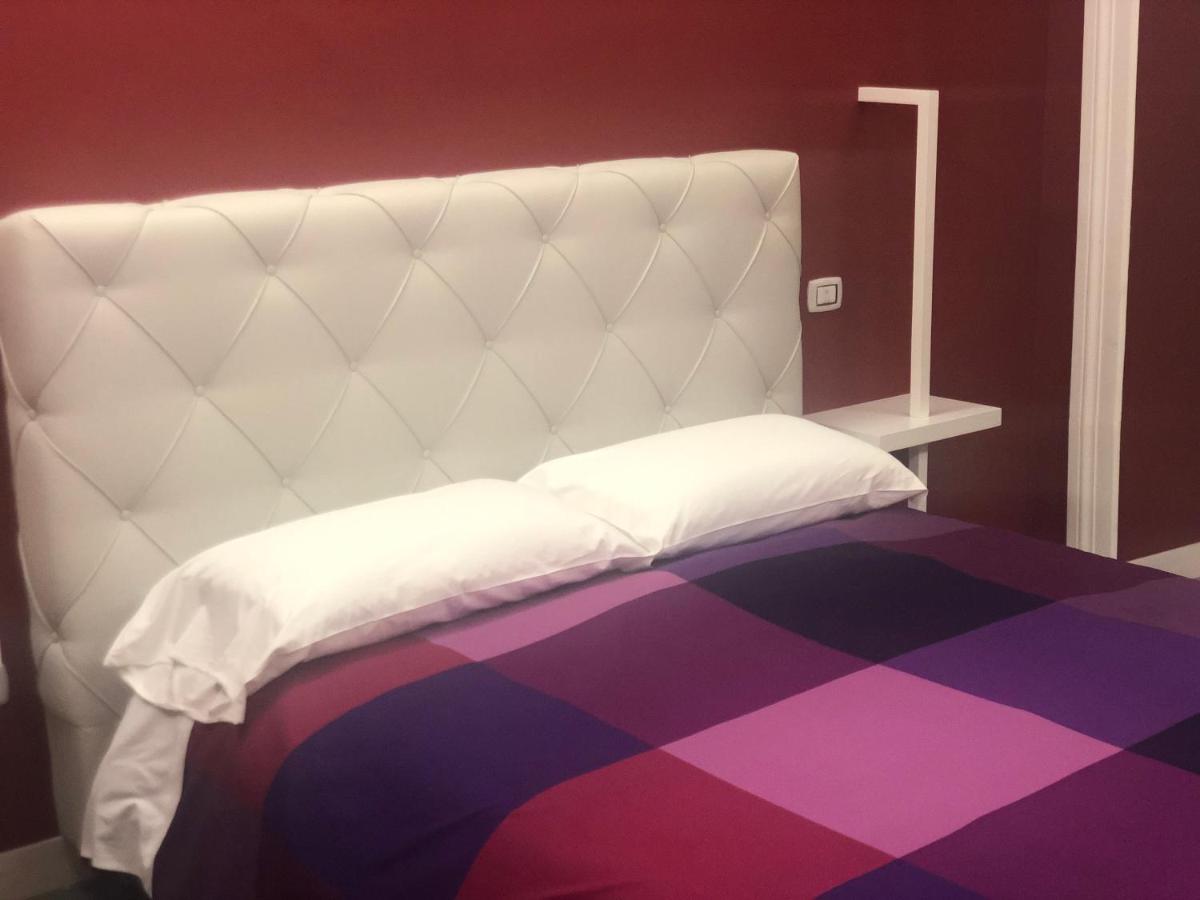 een wit bed met een paars tapijt bij SUNSET BED AND BREAKFAST in Napels