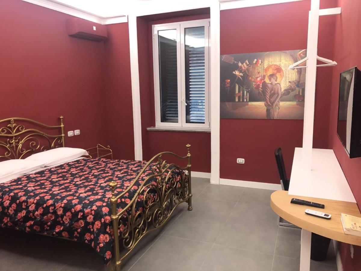 een slaapkamer met een bed, een tafel en een raam bij SUNSET BED AND BREAKFAST in Napels