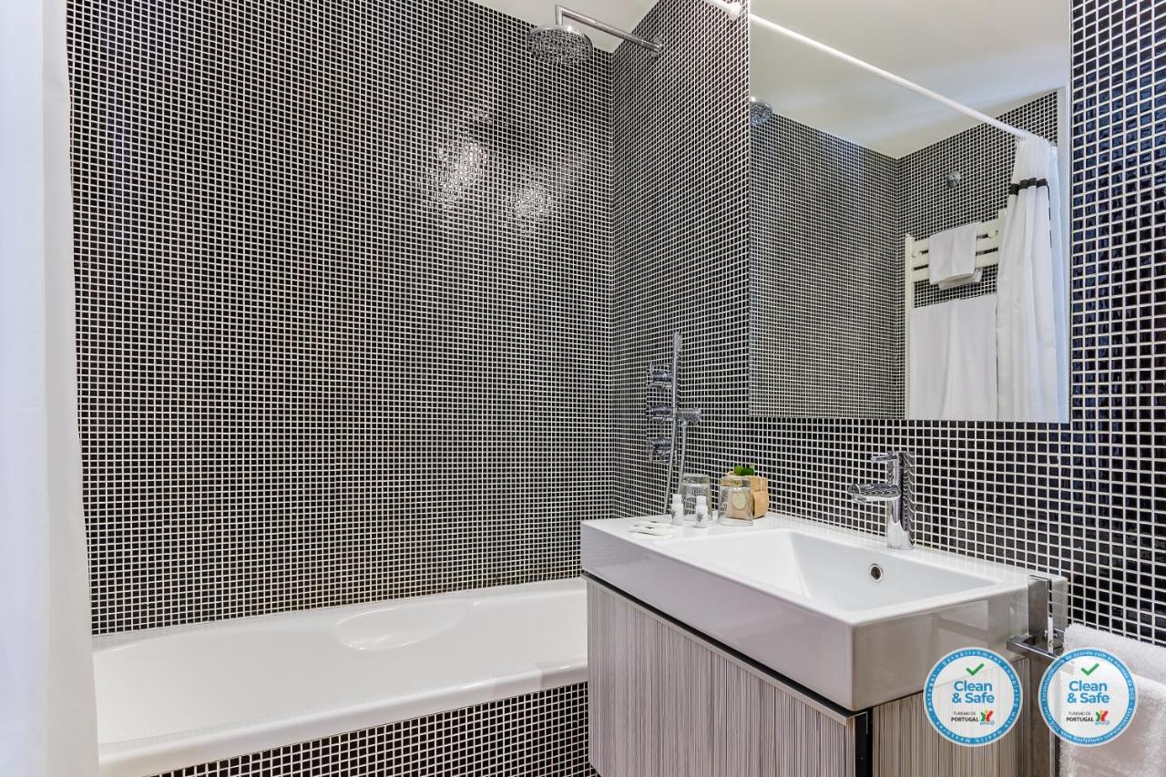 een badkamer met een wastafel en een badkuip en een wastafel bij RS Porto Boavista Studios in Porto