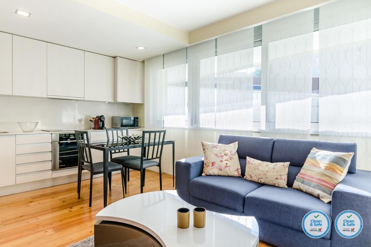 een woonkamer met een blauwe bank en een tafel bij RS Porto Boavista Studios in Porto +17 foto's