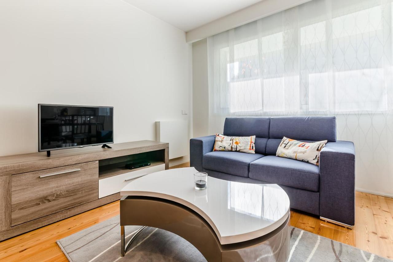 een woonkamer met een blauwe bank en een tv bij RS Porto Boavista Studios in Porto