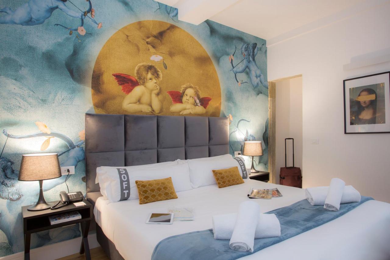 een slaapkamer met een bed met engelen op de muur bij Casual Rinascimento Firenze by Casual Hoteles in Florence