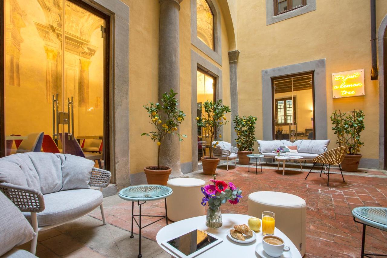 een terras met banken, tafels en stoelen bij Casual Rinascimento Firenze by Casual Hoteles in Florence