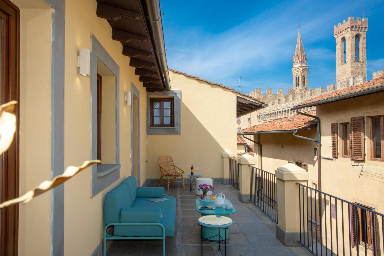 een balkon met een blauwe stoel en tafels op een gebouw bij Casual Rinascimento Firenze by Casual Hoteles in Florence