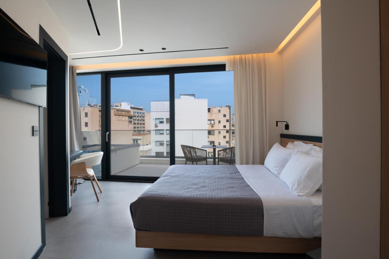 een slaapkamer met een bed en een balkon met uitzicht bij Nema Hotel Athens in Athene