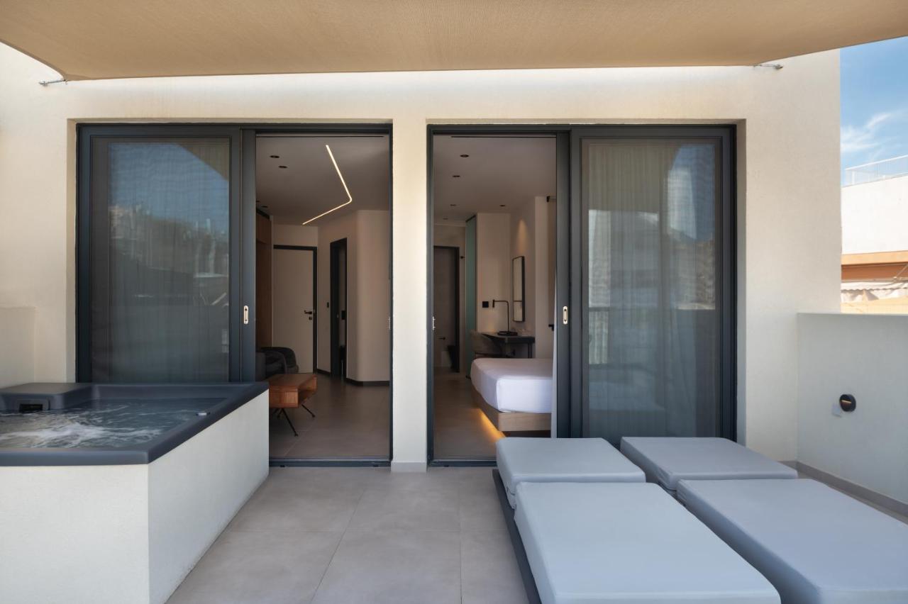 een kamer met schuifdeuren van glas en een slaapkamer bij Nema Hotel Athens in Athene
