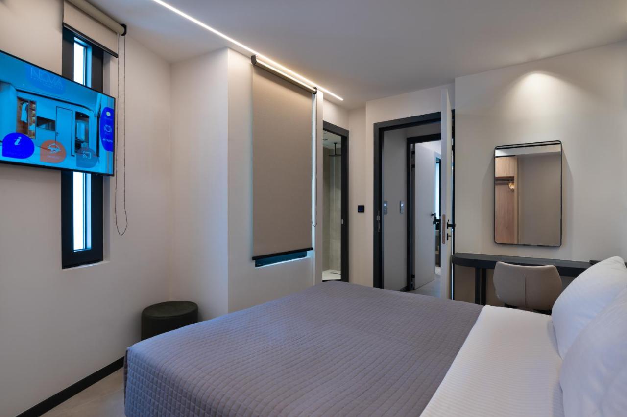 een slaapkamer met een wit bed en een paar ramen bij Nema Hotel Athens in Athene