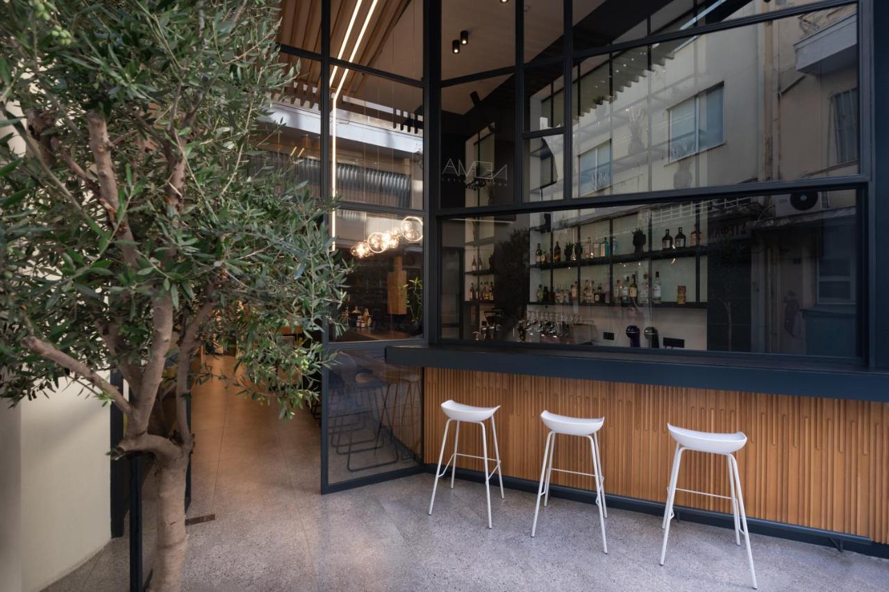 een bar met witte barkrukken voor een gebouw bij Nema Hotel Athens in Athene