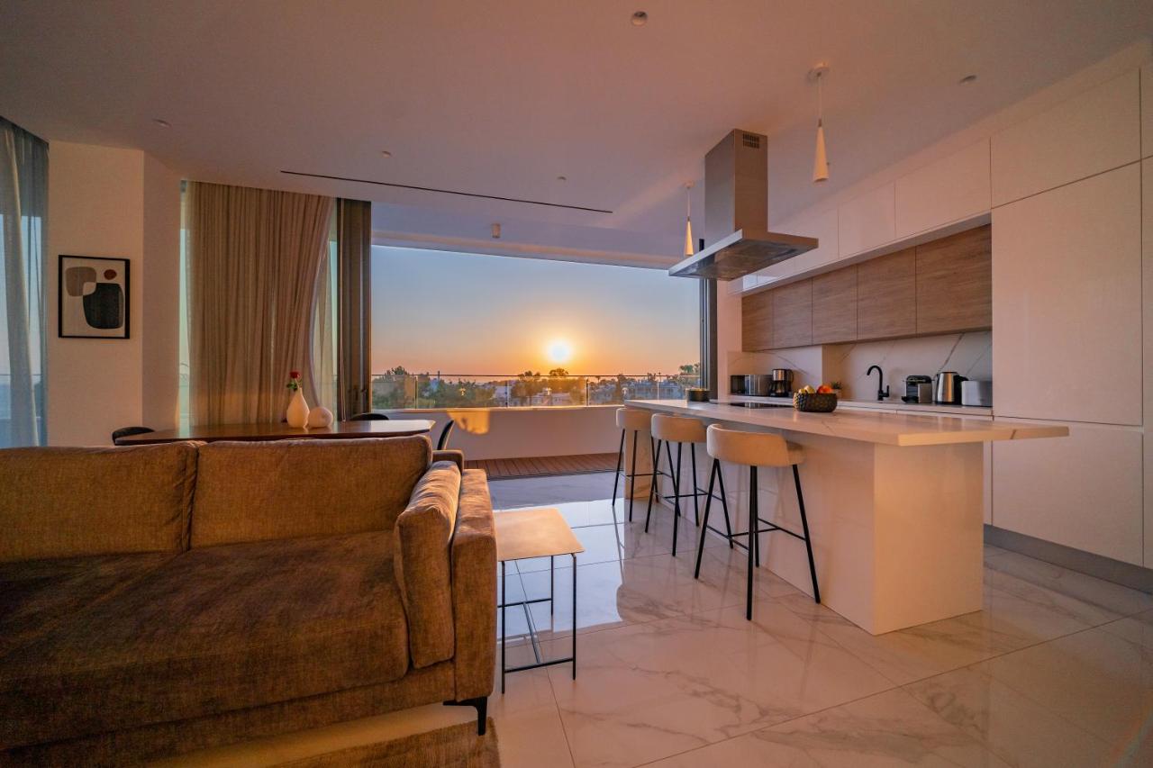 een woonkamer en keuken met een bank en een aanrecht bij The Palmiers by Deserve in Paphos City