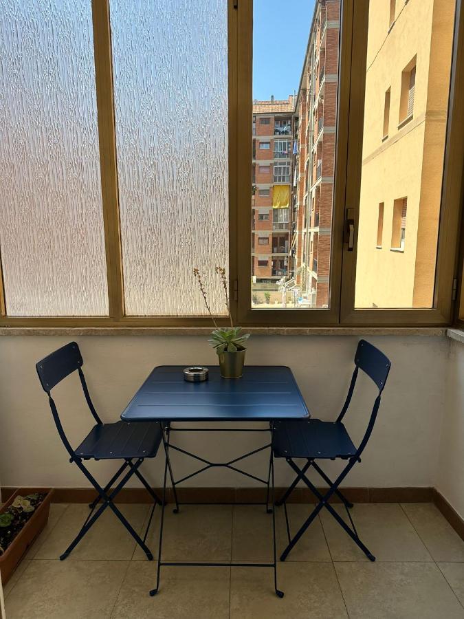 een tafel en twee stoelen in een kamer met twee ramen bij Affittacamere Dianir in Rome