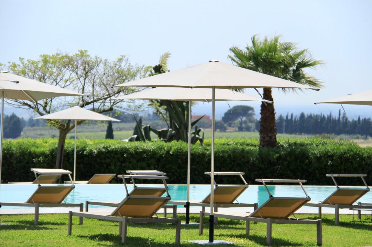 een groep stoelen en parasols naast een zwembad bij Masseria del Carboj in Menfi