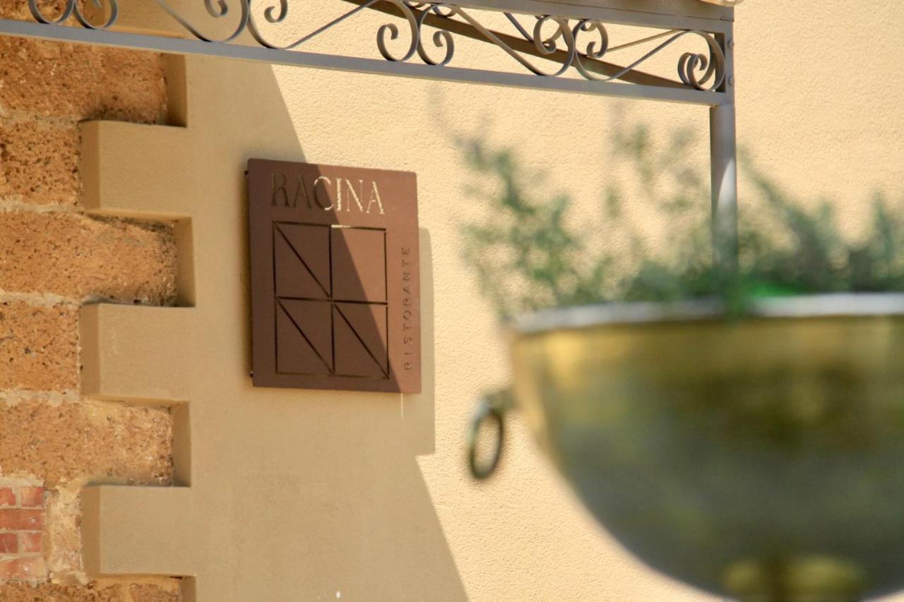 een bord aan de zijkant van een muur met een vaas bij Masseria del Carboj in Menfi
