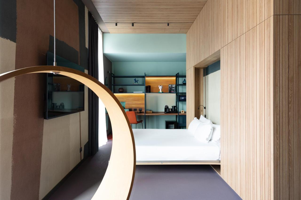 een slaapkamer met een wit bed en een houten muur bij 21 House of Stories Navigli in Milaan