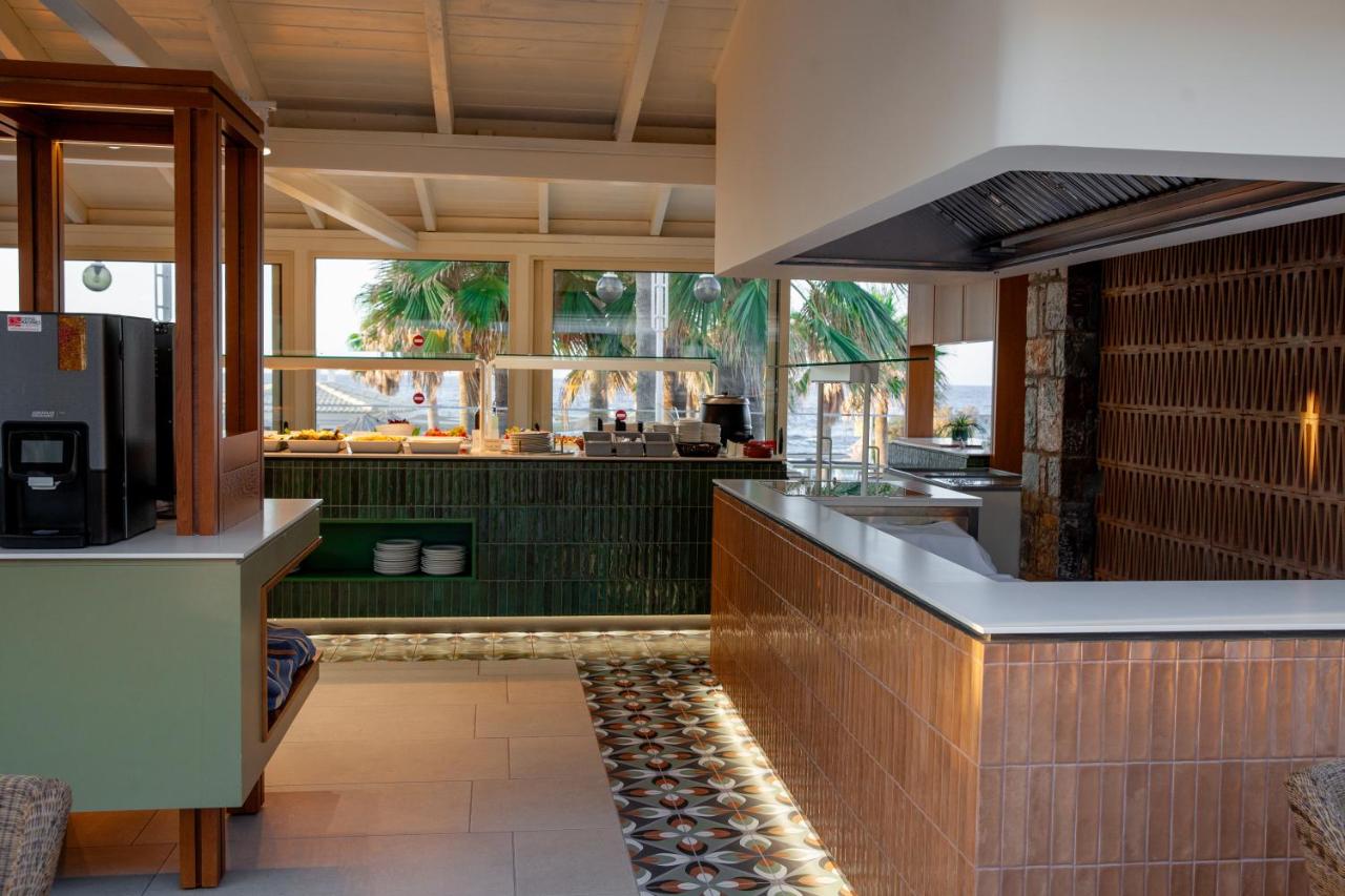 een restaurant met een keuken met groene muren bij Aeolos Beach Resort in Malia