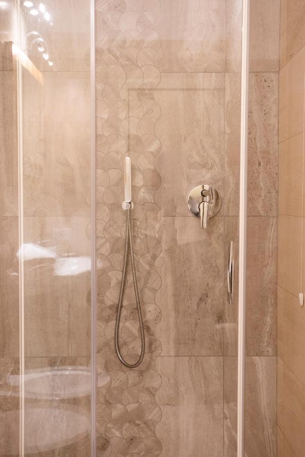 een douche met een glazen deur en een douche bij Hotel Meeting in Stresa