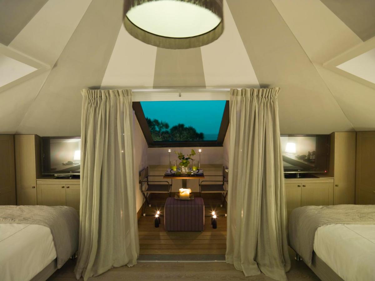 een slaapkamer met twee bedden en een kamer met een raam bij Eight Hotel Paraggi in Santa Margherita Ligure