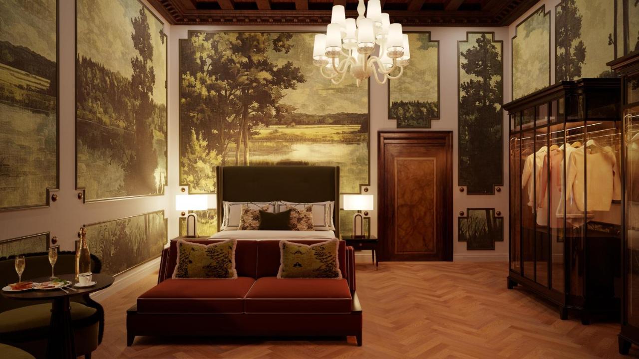 een slaapkamer met een bed, een bank en een kroonluchter bij Eight Venezia in Venetië +46 foto's